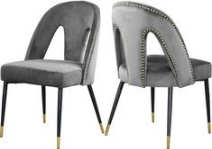 pair of grey velvet chairs with gold studdings and black legs, side view