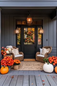 the front porch is decorated for fall with pumpkins and flowers on the floor, along with two wicker chairs