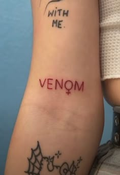 a woman's arm with the word venom tattooed on it