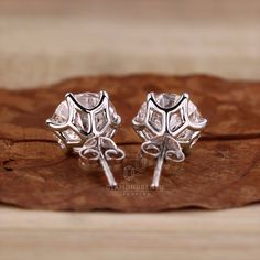 pair of silver earrings with clear stones on wooden surface