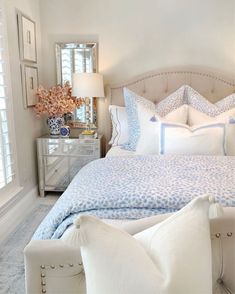 a white bed with blue and white pillows