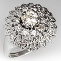 This vintage diamond ring is centered with one (1) old European cut diamond set into a four-prong setting. The inner halo is accented with ten (10) round single cut diamonds set into four-prong setting. The outer halo setting is accented with twenty (20) round single cut diamonds bead set into petal shaped settings. The ring measures 17.1mm at the top, rises 9.6mm above the finger, tapering to 1.7mm wide and 1.0mm thick at the base of the shank. Two of the diamond melee have small chips that cannot be seen with the unaided eye. The ring is currently a size 6.25. Fancy Decorations, Antique Cocktail Ring, Vintage Diamond Ring, Vintage Diamond Rings, Halo Setting, Dream Engagement Rings, Diamond Cocktail Rings, European Cut Diamonds, Antique Diamond