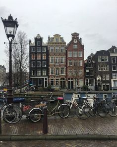 several bicycles are parked next to each other in front of some buildings and a lamp post