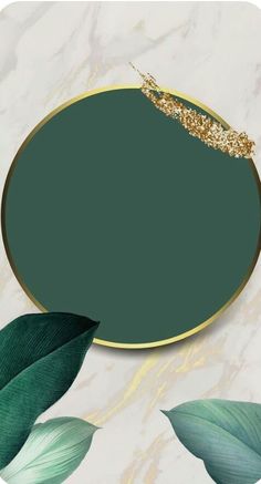 a green and gold plate with leaves around it on a white marble tablecloth background