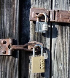 an old lock and padlock on a wooden door