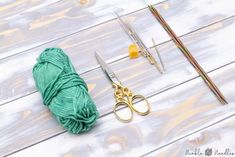 yarn, scissors and knitting needles laid out on a table