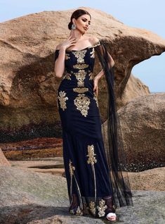 Worthy of a red carpet entrance, this breathtaking prom dress combines elegance and drama in perfect harmony. The rich navy blue fabric is beautifully adorned with golden embroidery, creating a luxurious and eye-catching design. The off-the-shoulder neckline adds a touch of romance, while the fitted bodice highlights your figure, ensuring you feel confident and glamorous. The long, sheer sleeves extend gracefully, adding a dramatic flair to the ensemble. The floor-length skirt features a slight High Neck Long Sleeve Wedding Dress, Gold Ball Gown, Lace Party Dresses, Black Tulle, Sleeve Wedding Dress, High Neck Long Sleeve, Long Sleeve Wedding, Evening Attire, Glamorous Evening Gowns