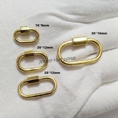 three pairs of gold metal buckles are shown on a white t - shirt with measurements