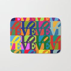 a colorful bath mat with the words live love believe in multicolored letters on it