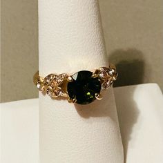 This Is A Stunning New Gold-Tone Ring Featuring A Central Dark Green Gemstone That Exudes Elegance. The Central Stone, A Green Colored Gem, Is Gracefully Accentuated By An Intricate Pattern Of Smaller Clear Gemstones, Possibly Cubic Zirconia Or Diamonds. These Embellishments Adorn The Band, Adding A Delicate Touch Of Sparkle And Sophistication. Discounted Shipping!!! All Jewelry Items Come With A Mini Jewelry Polishing Cloth. And If It Did Have The Original Packaging You Will Get That Too. Somet 14k Gold Green Rings With Intricate Design, Elegant Green Crystal Ring In 14k Gold, Green Crystal Ring In 14k Gold, 14k Gold Green Crystal Ring With Ethical Gemstones, Elegant Green Multi-stone Crystal Ring, Colored Gems, Green Gemstones, Womens Jewelry Rings, Dark Green