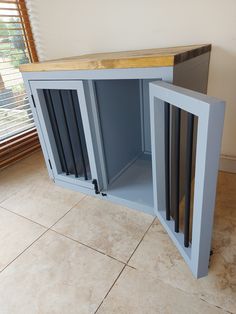 a dog door that is open on the floor next to a cabinet with bars in it