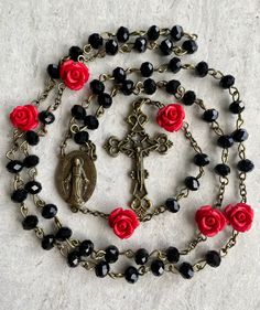 A beautiful handcrafted Catholic five decade chain style prayer rosary. It's a great and thoughtful gift for someone special. Made with black 6mm crystal beads for the decades, red rose accent 8mm beads for the Our Father's and bronze Crucifix and Virgin Mary medallion. Tampa is know for our rich history founded by the Spaniards and Italians. Every year our city is taken over by pirates for the Gasparilla Parade. This rosary is inspired by the Spanish pirates that once called our city home.  Eac Crucifix Jewelry With Black Beads As Gift, Black Beads Cross Rosary Gift, Vintage Black Rosary Gift, Vintage Black Rosary As Gift, Vintage Black Rosary As A Gift, Black Cross Rosary As Gift, Black Crucifix Rosary As Gift, Black Crucifix Rosary Bracelet As Gift, Handmade Black Rosary Gift