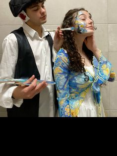 a man and woman are dressed up in costumes, one is brushing the other's teeth