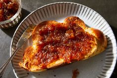 a heart shaped piece of bread with sauce on it sitting on a plate next to a fork