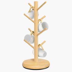 a wooden rack with cups and spoons in it on top of a white background