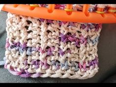 a crocheted bag with an orange handle on the top and two different colored handles