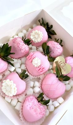 a box filled with pink and white chocolate covered strawberries