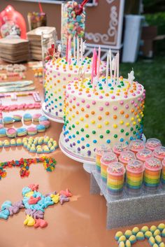 a table topped with lots of cakes and cupcakes