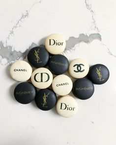 black and white rocks with the names of chanel, dior, d'or