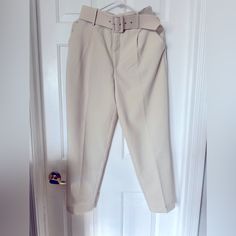 Elevate Your Wardrobe With These Stylish High-Waisted Pants From Zara. Perfect For Any Occasion, These Pants Feature A Solid Pattern And A Cream Color That Complements Any Outfit. The Pants Are Made Of Polyester Material And Have A Pleated Front Type, A Classic Fit, And A Straight Leg Style. The Pants Come With A Fabric-Covered Belt That Adds An Extra Touch Of Elegance To The Outfit. The Belted Feature Is Perfect For Travel, Party/Cocktail, Casual, And Business Occasions. These Pants Are Availab Belted High-waisted Pants For Spring, Belted Beige Trousers, Spring High-waisted Belted Pants, Trendy Belted Trousers, Belted High Waist Bottoms For Spring, Belted Trousers For Spring, Spring Belted Trousers, High Waist Pants For Office In Summer, High Waist Office Pants For Summer