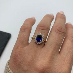 a woman's hand with a ring on it and a blue stone in the middle