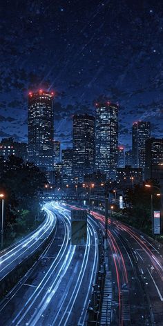 the city skyline is lit up at night, with long exposures on the road