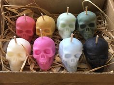 a box filled with different colored skull candles