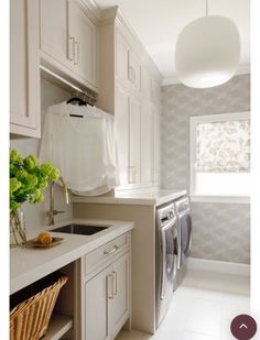 a laundry room with white cabinets and an ironing board