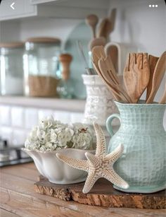 a wooden table topped with white dishes and starfish figurines on top of it