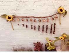 sunflowers are hanging from a branch with numbers and beads attached to the branches