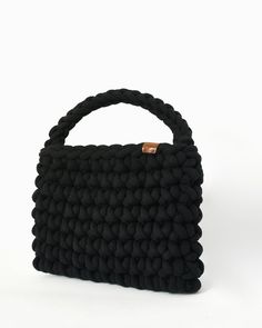 A unique handmade black bag with an impressive weave thanks to its thick yarn. 100% recycled cotton thread and ecological leather tag with the CrosiS brand were used. The woven strap gives the bag a surprising simplicity and harmony. The interior is made of high quality upholstery. A special bag for the woman looking for minimal style and comfort. This bag will become the favorite part of your wardrobe as with its impressive and simple knitting you will be able to easily combine it with many out Black Knitted Rectangular Bag, Black Knitted Rectangular Shoulder Bag, Black Crochet Bag With Leather Handles, Black Crochet Bag With Braided Handles For Everyday Use, Everyday Black Crochet Bag With Braided Handles, Black Knitted Crochet Tote Bag, Black Crochet Shoulder Bag For Everyday, Black Crochet Top Handle Bag For Everyday, Everyday Black Crochet Top Handle Bag