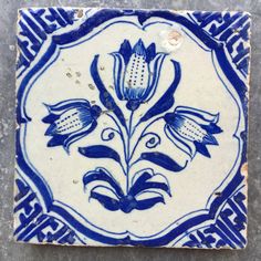 a blue and white tile with flowers on it