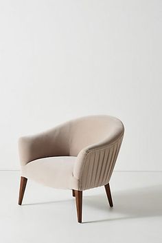 a beige chair sitting on top of a white floor