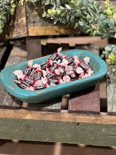 a blue bowl filled with candy on top of a wooden table