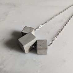 Stainless steel paper clip chain with three concrete cubes. Great for layering and everyday wear. If you would like a different length, send us a message. ➕Packaging Each of our concrete necklaces come in a jewelry box with a jewelry backing card with our logo. Looking for more stainless steel jewelry? Check out our collection: https://www.etsy.com/shop/woodstonecollection ➕Socials Instagram: @woodandstonecollection Facebook: www.facebook.com/woodandstone Web: www.peridotdesign.com/shop Gray Sterling Silver Necklace Gift, Minimalist Gray Sterling Silver Jewelry, Gray Sterling Silver Necklace For Gift, Minimalist Gray Jewelry For Everyday, Gray Minimalist Jewelry For Everyday, Gray Minimalist Jewelry For Everyday Wear, Concrete Necklace, Backing Card, Steel Jewelry