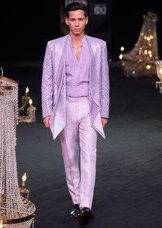 Elevate your evening ensemble with our expertly crafted three-piece tuxedo set. Crafted on a glamorous shimmer base. This lavender tuxedo is ornate with hand embroidered cutdana work and lapel detailing. Complemented with a pleated shirt and straight pants. This glitzy outfit will command everyone's attention. Dry-clean only if required. Slight variation in color is possible due to digital photography. Tailored Evening Party Wear Suits, Elegant Formal Sets With Sequins, Elegant Formal Sequined Sets, Elegant Formal Sequin Sets, Luxury Fitted Evening Sets, Luxury Fitted Evening Set, Glamorous Tailored Wedding Suits, Glamorous Formal Sets With Sequins, Glamorous Formal Sequined Sets