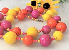 "30\" Brite Bubble Beaded Orange/Pink/Yellow Multi Lucite Necklace & Matching Cluster Clip On Earrings Pink/Yellow/Orange Alternating Beads with Mini Beads Large Beads Measure 3/4\" in Diameter Smaller Beads Measure 5/8\" in Diameter Silver Tone Lobster Clasp Cluster Clip On Earrings Measure 1 1/8\" in Diameter Made in USA Necklace/Earrings Set 42.00 Necklace Only 29.00 Cluster Earrings Only 15.00 COMPLIMENTARY DOMESTIC SHIPPING" Yellow Round Bead Necklaces For Summer, Yellow Round Beads Necklace For Summer, Yellow Beaded Necklaces With Large Beads For Summer, Summer Yellow Beaded Necklaces With Large Beads, Vibrant Pink Round Bead Jewelry, Vibrant Pink Round Beaded Jewelry, Vibrant Yellow Beaded Jewelry, Colorful Beaded Necklaces In Yellow, Yellow Wooden Beads For Jewelry Making