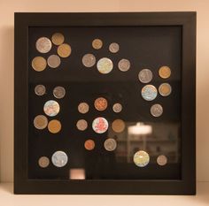 a black frame with lots of different colored coins on the front and bottom, along with a lamp