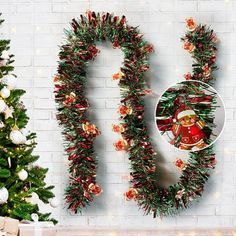 two christmas trees are decorated with red and green garlands in front of a brick wall