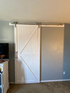 an empty room with a sliding barn door