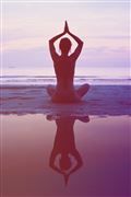 a person sitting in the water with their hands up to their head while doing yoga