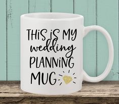 this is my wedding planning mug on a wooden table next to a green painted wall