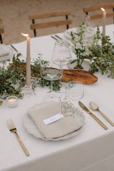 a table set with place settings and candles