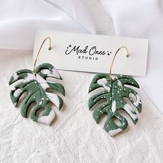 a pair of green and white leaf earrings