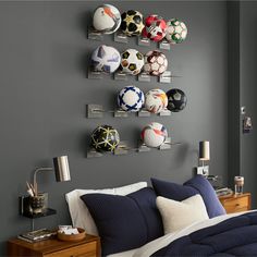 a bedroom with soccer balls mounted to the wall and shelves on the wall above it