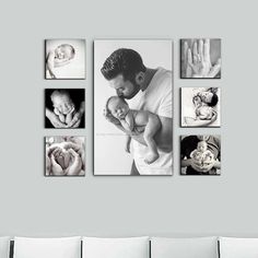 a man holding a baby in his arms while hanging on a wall with multiple pictures