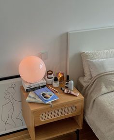 a bedroom with a bed, nightstand and lamp on top of the night stand in front of the bed