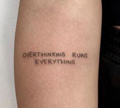 a person with a tattoo on their arm that says, overthiking runs everything