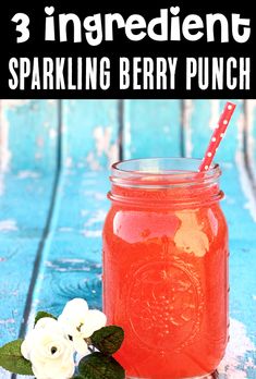 a mason jar filled with sparkling berry punch on top of a blue table next to white flowers