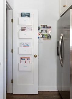 a white door with magnets on it in a kitchen next to a silver refrigerator